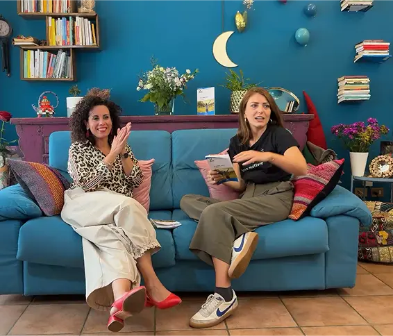 The two hosts on the couch — side view